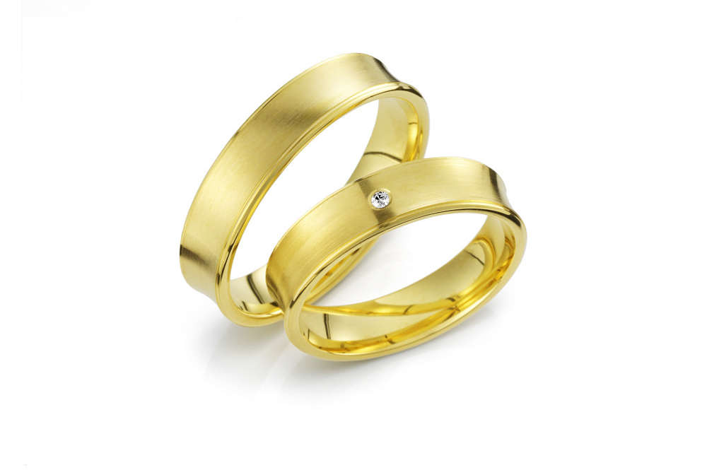 Vielsesringe Vielsesringe i guld med en indadkurvet ringskinne med brilliantslebet diamant placeret i midten.